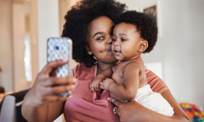 Person holding phone with baby